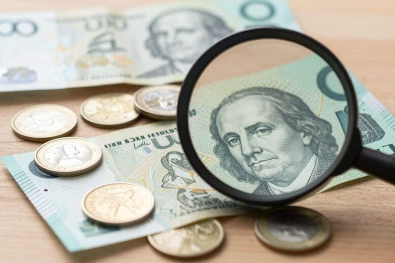 Australian money with a magnifying glass over it.