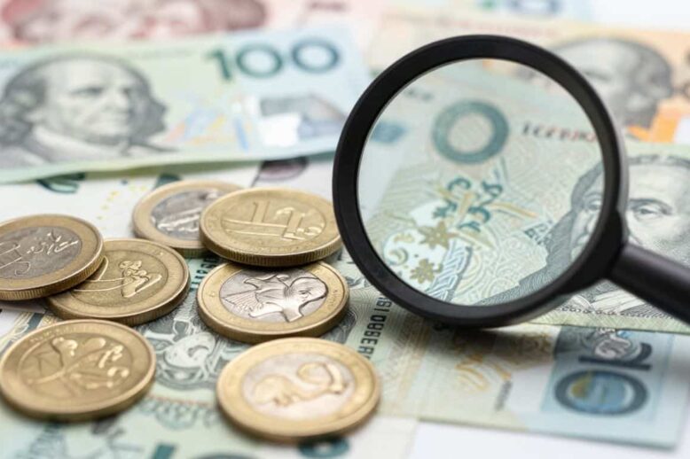 Australian dollars and magnifying glass for CFD tax declaration.