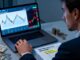 A CFD trader moving from a risk-free demo account to the emotional pressure of live trading, with market charts, real money, and disciplined risk management visible in the scene.